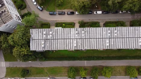 aerial view of residential building rooftop with parked cars on nearby street