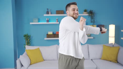 Young-fitness-instructor-doing-arm-stretching-and-stretching-exercises-at-home,-looking-at-camera.