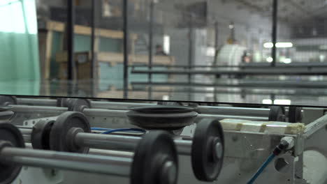 a big glass panel on a transport roller in glass factory