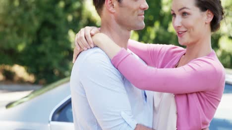 Couple-interacting-with-each-other-near-car