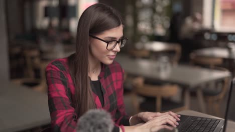 hermosa chica escribiendo en su portátil en la cafetería