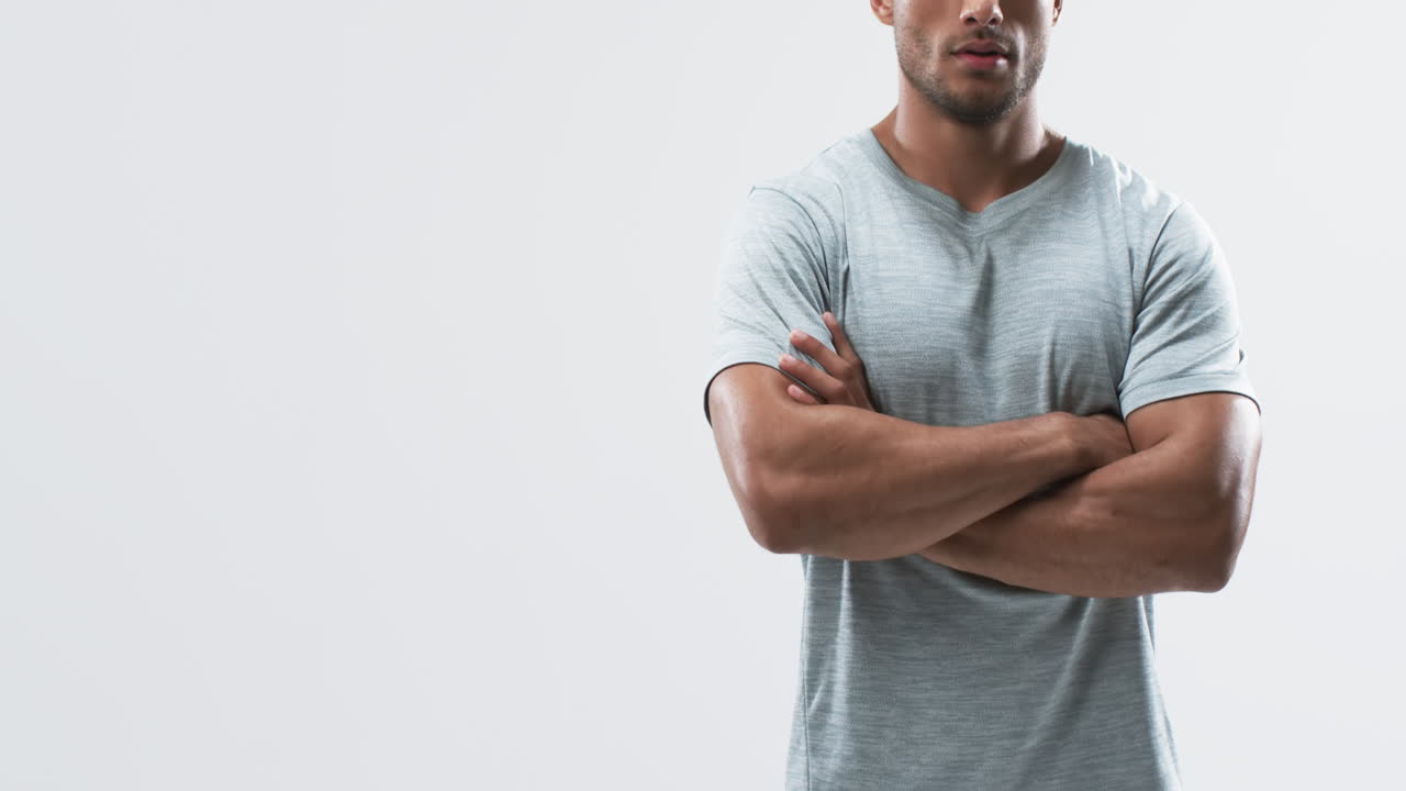 젊은 양색 운동선수 남자가  바탕에 복사 공간을 가지고 자신감 있게 서 있습니다.