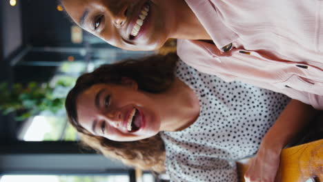 Vídeo-Vertical-De-Dos-Jóvenes-Amigas-Reunidas-En-Una-Cafetería-Y-Posando-Para-Un-Selfie