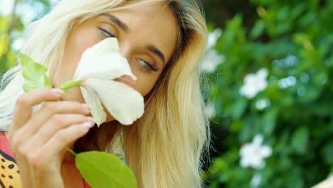 The-woman-is-sniffing-the-flower-in-her-hand