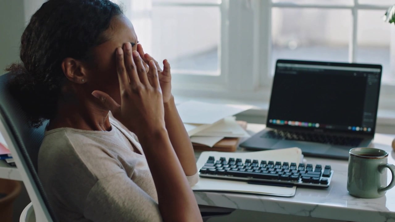 Pausing work, home worker in light sweater rubbing eyes, pressing nose, taking short laptop break