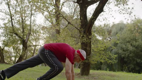 Aktiver-älterer-Mann-Macht-Liegestütze-Übungen-Im-Park.-Großvater-Trainiert-Fitnesstraining