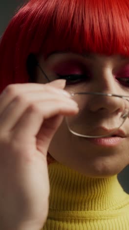 woman with red wig, glasses, and makeup