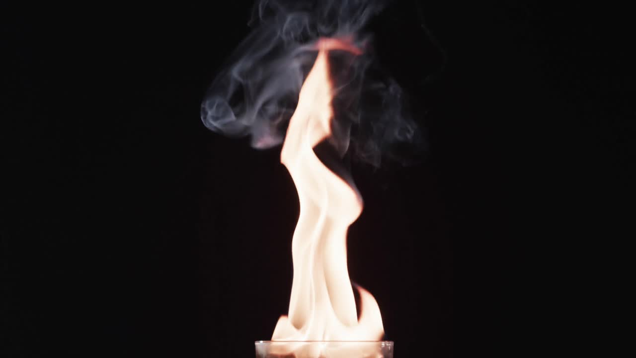 video de alcohol encendido en vidrio con llamas de fuego amarillas y espacio de copia en fondo negro
