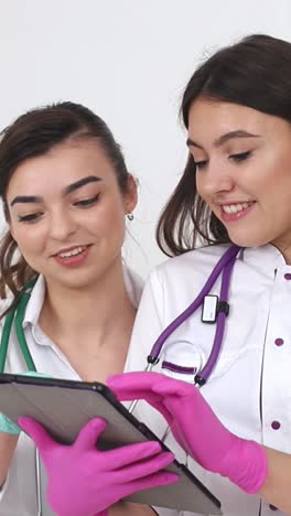 two female doctors consulting together on a tablet
