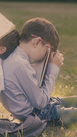 cute little schoolboys wearing shirts jeans relax after hard study day holding books on face close view slow motion