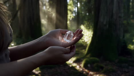 hands holding a luminous crystal in an enchanted forest