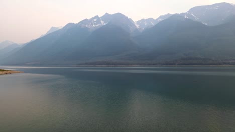 stunning rocky mountains bordering kinbasket lake during wildfires near canoe reach in valemount, british columbia, canada