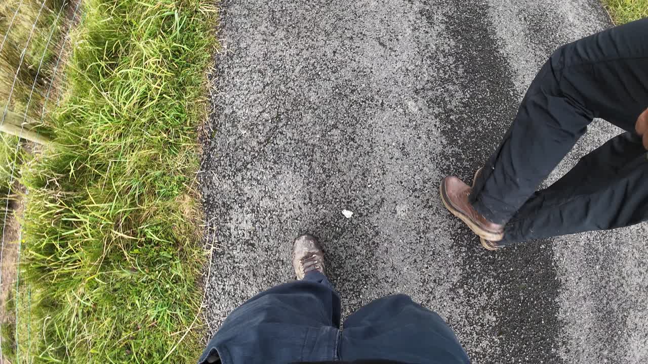 Experience a tranquil walk along a deserted road in Brecon Beacons National Park. The overcast sky casts soft light over rolling hills and rugged terrain, offering a serene adventure