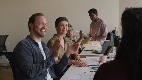 diverse business team applauds during office meeting