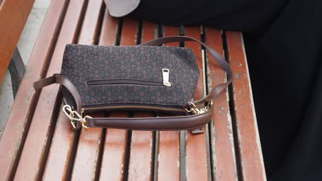 brown shoulder bag on wooden bench