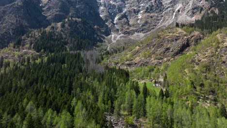 A-dynamic-aerial-shot-of-the-beautiful-mountains-descending-to-a-house-somewhere-at-the-Italian-Piemont-region,-Southern-Alps