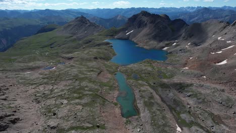 Vista-Aérea-Del-Lago-Glacial-Bajo-Las-Colinas-Del-Parque-Nacional-De-Las-Montañas-Rocosas,-Colorado,-Ee.uu.