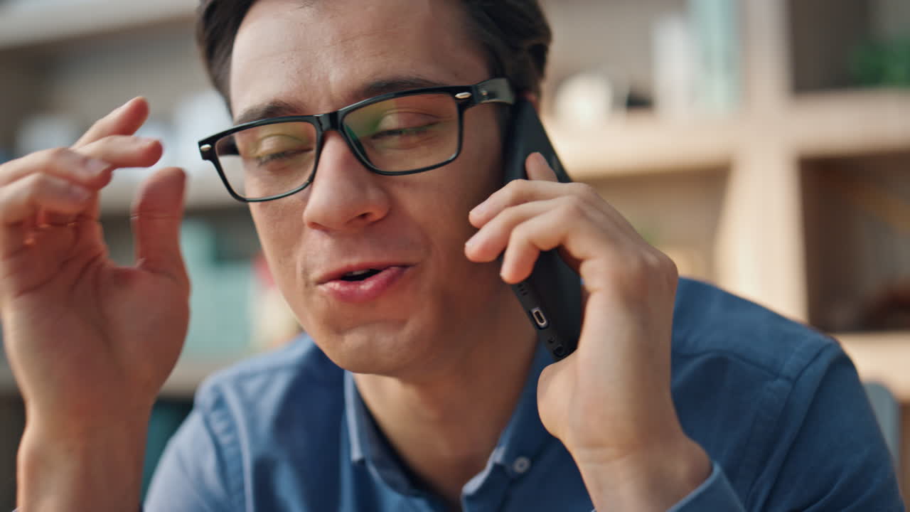 웃는 사업가 사무실에서 스마트폰으로 전화하는 클로즈업.