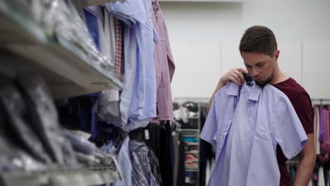 hombre comprando camisas en una tienda de ropa