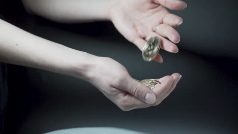 tirando monedas bitcoin de una mano a otra, fondo negro
