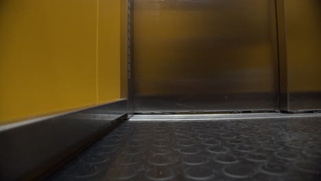 apertura de la puerta del ascensor, vista desde el interior. escalera mecánica amarilla