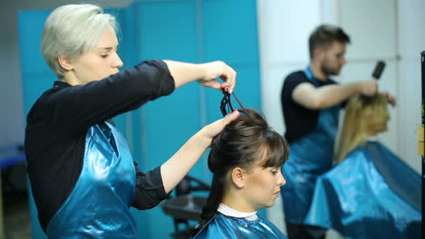 professional hairdresser cutting hair. young woman and hairdresser making styling hair at beaty salon