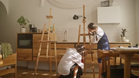 hermanas preparando un caballete para pintar