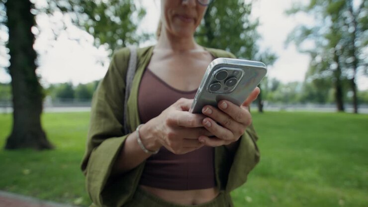 Donna che utilizza il telefono nel parco
