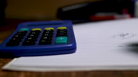 pan left to right of a calculator and notepad and pen