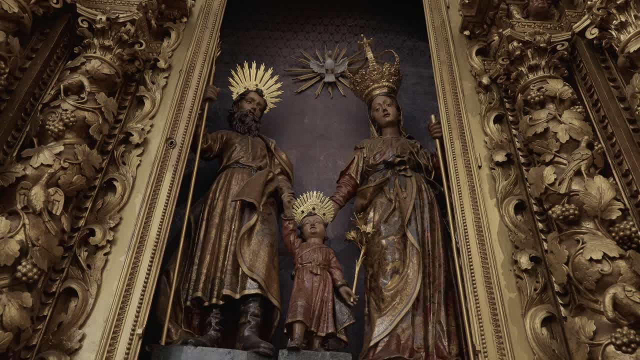Altar dorado ornamentado con estatuas de la Sagrada Familia dentro de una iglesia católica histórica.