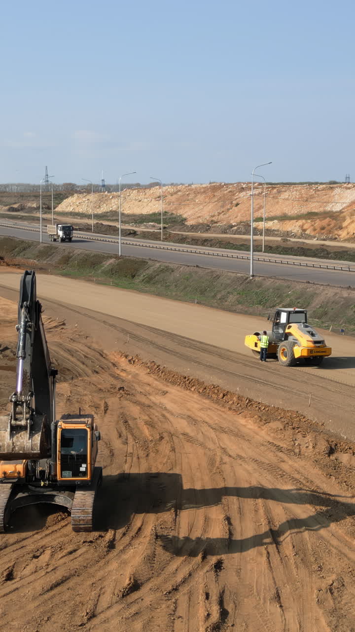 Heavy Equipment at a Road Construction Site with Excavator and Road Roller