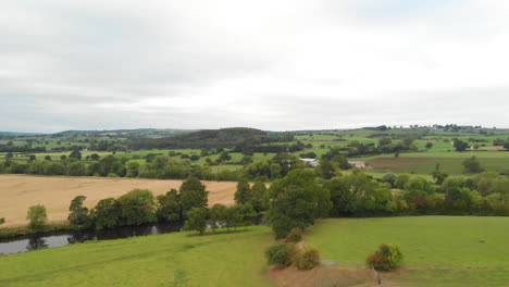 dron volando sobre campos verdes y ríos con colinas en el horizonte imágenes cinematográficas de drones en yorkshire
