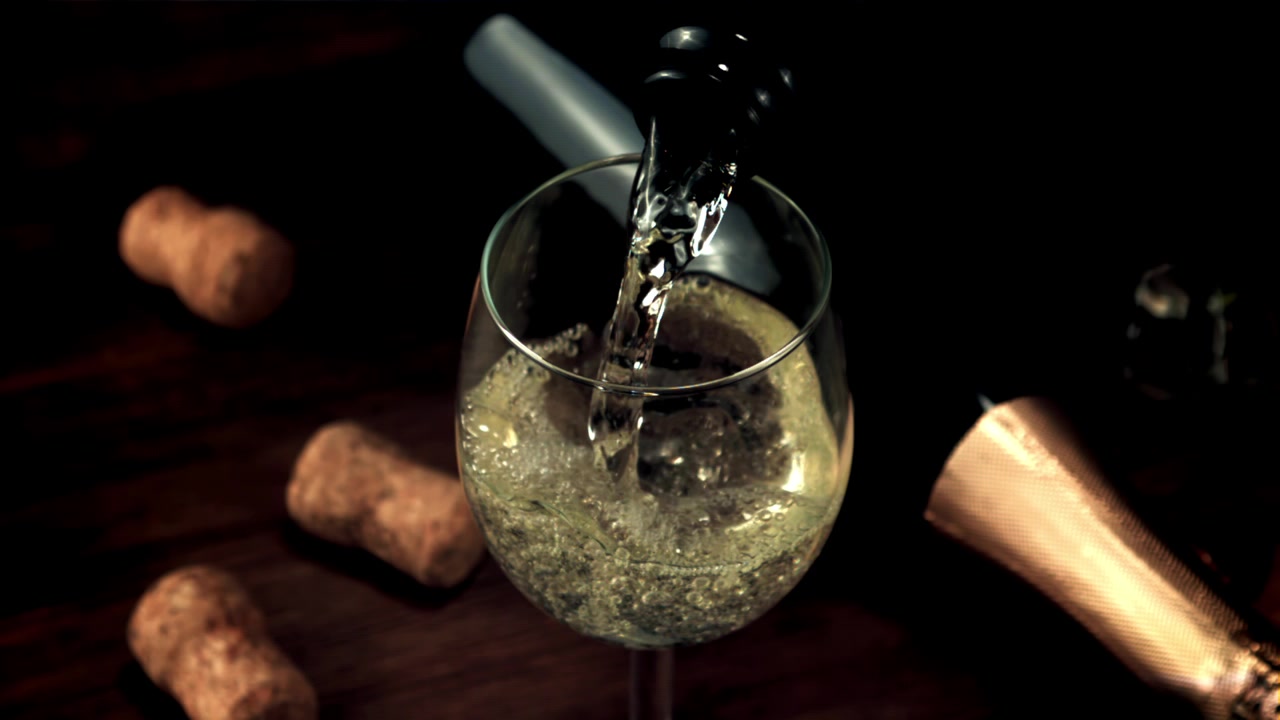 Versamento di vino spumante in un bicchiere al rallentatore