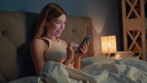 girl watching cellphone social media at bedtime close up. woman reading message