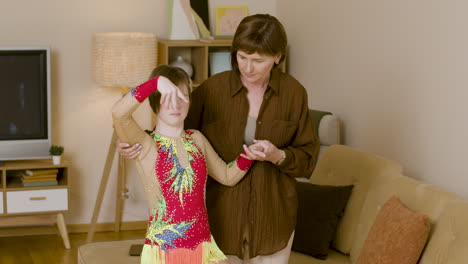 Teenager-dancing-and-posing-while-her-mother-helps-her-at-home