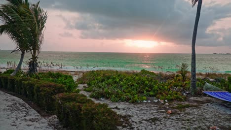 Zeitraffer-An-Einem-Windigen-Inselstrand-Mit-Hängematte-Bei-Sonnenuntergang