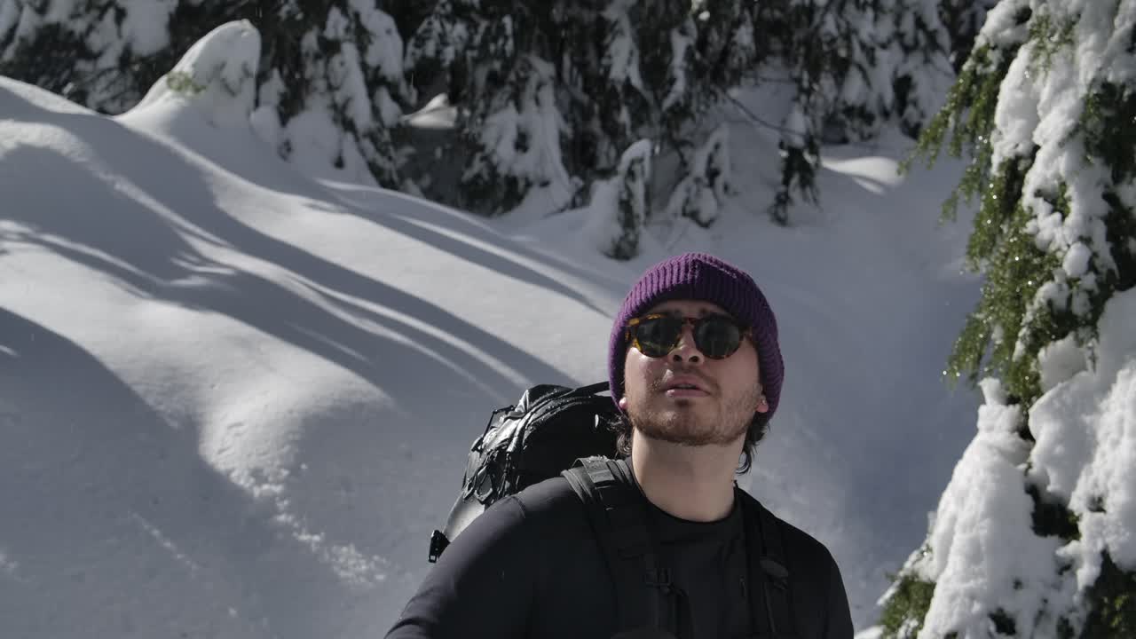 mochilero con sombrero de gorra y gafas de sol admirando el paisaje del bosque a principios de primavera después del invierno