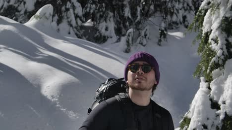 Backpacker-In-Beanie-Hat-And-Sunglasses-Admiring-Forest-Scenery-In-Early-Spring-After-Winter