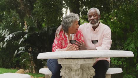 una pareja mayor afroamericana disfrutando de una copa de vino en distanciamiento social