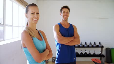 Hombre-Y-Mujer-Con-Las-Manos-Cruzadas-Sonriendo-En-El-Gimnasio-4k