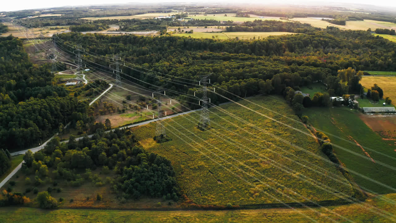 Aerial Flyover of High Voltage Transmission Power Lines Passing through Forest in Rural Countryside