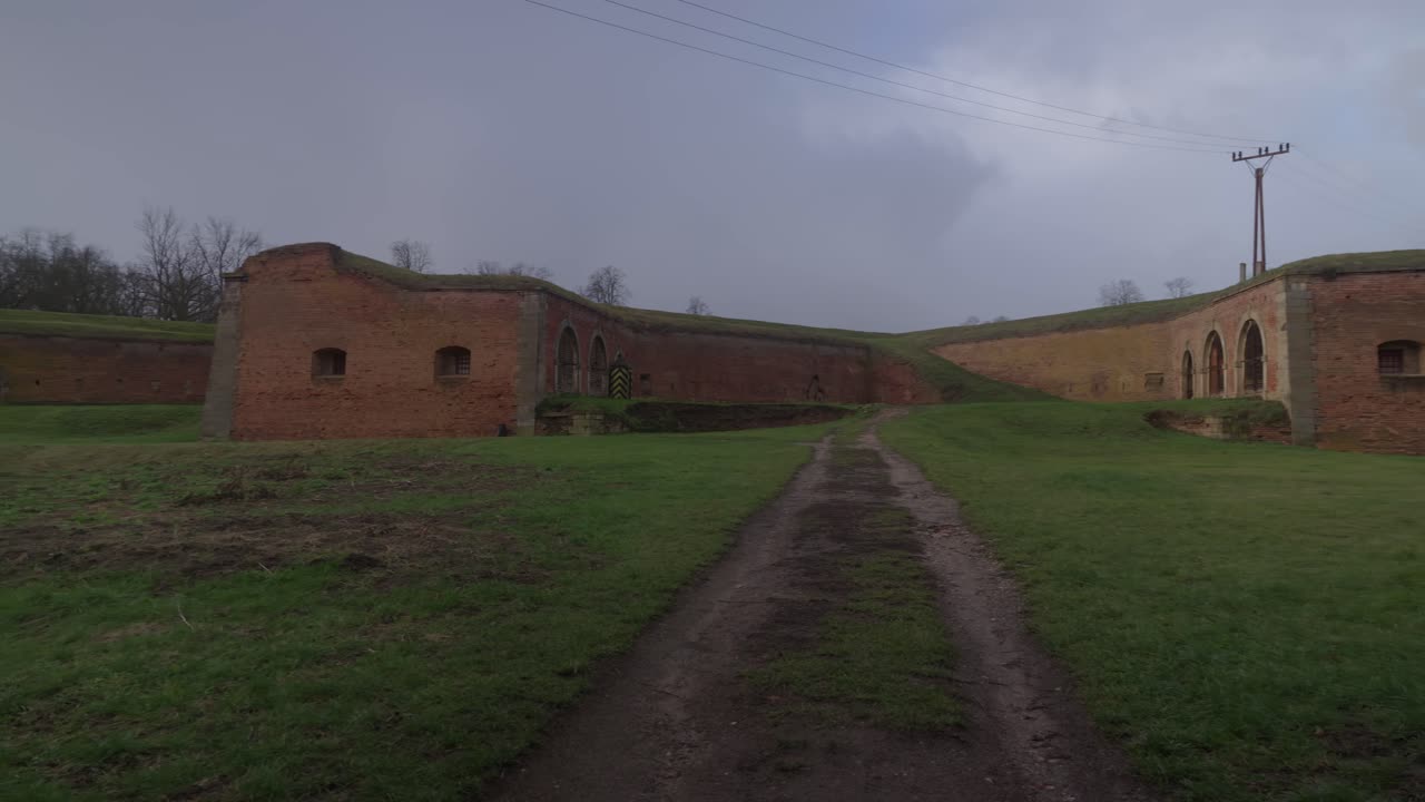 A grassy area bordered by the brick walls of the Terez&iacute;n Fortress