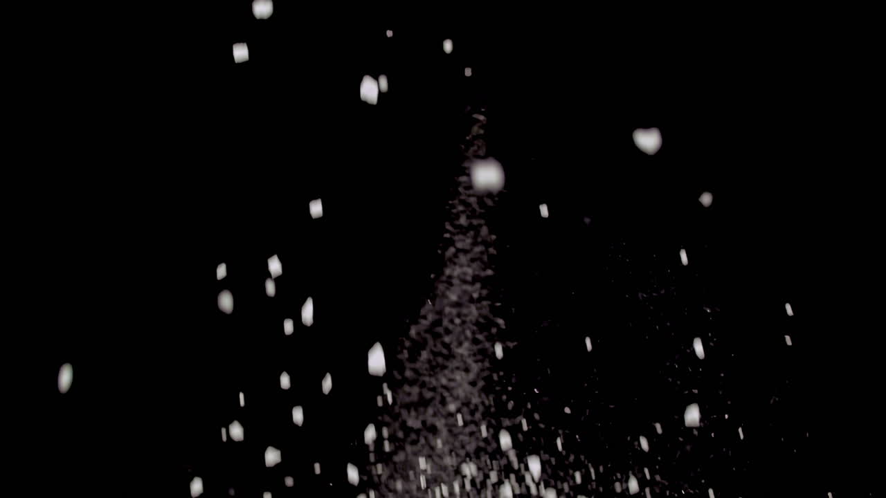 Fresh green bell peppers displayed whole on dark background in minimalist composition thrown into air with flaky salt, slow motion