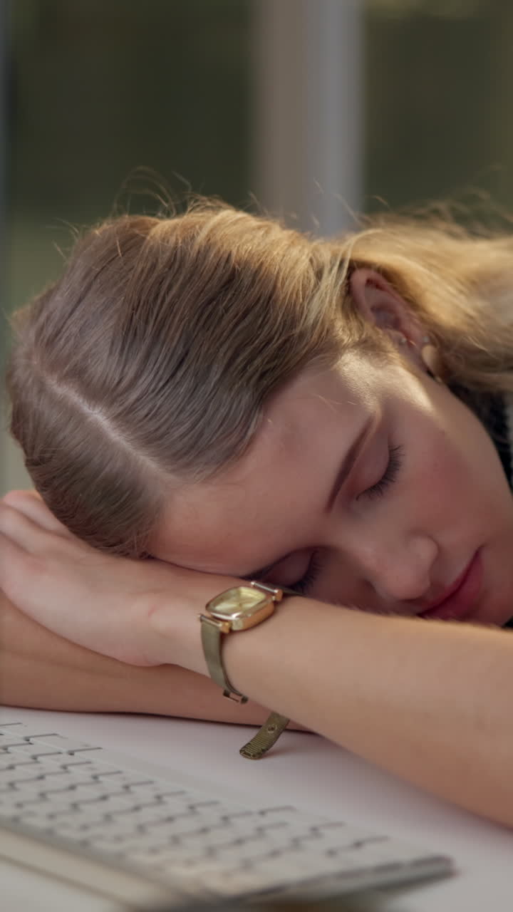 Donna che fa un pisolino alla sua scrivania