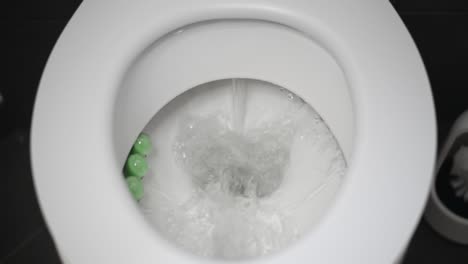 pequeño trozo de papel higiénico tirado por un inodoro blanco