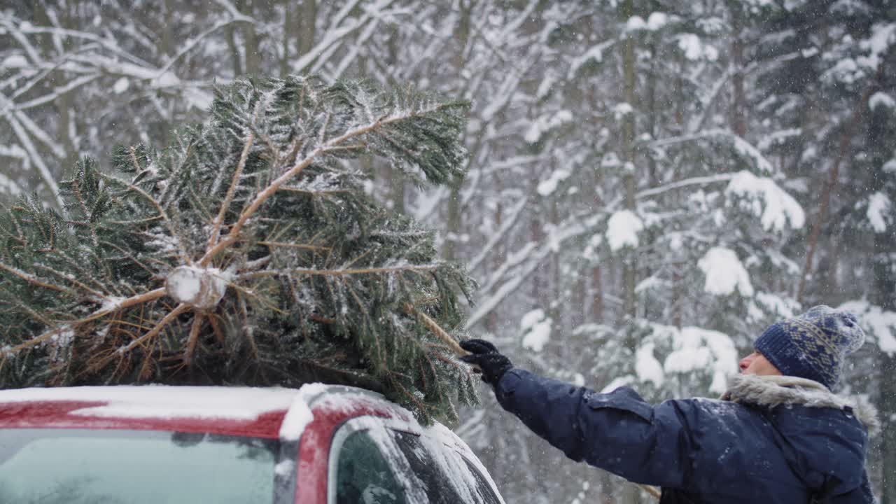 hombre con padre mayor adjunta árbol de navidad al coche