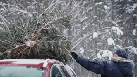 Mann-Mit-älterem-Vater-Befestigt-Weihnachtsbaum-Am-Auto