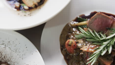 Prepared-and-decorated-meal-on-white-plate-in-kitchen,-slow-motion