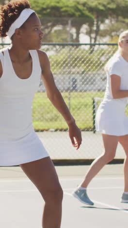 video of happy diverse female tennis players exercising on court