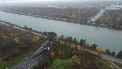 aerial shot cars driving on a highway that crosses a river in the niagara region